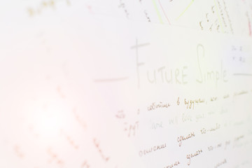 Close-up handwriting English grammar rules on white sheet of paper. Lens flare effect