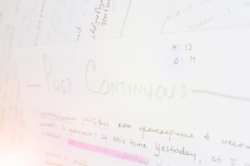 Close-up handwriting English grammar rules on white sheet of paper. Lens flare effect