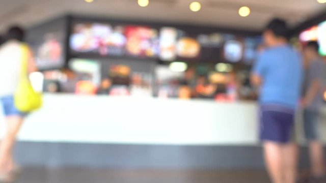 Customers order fast food at counter stay in queue wating to buy some burger, blur people background