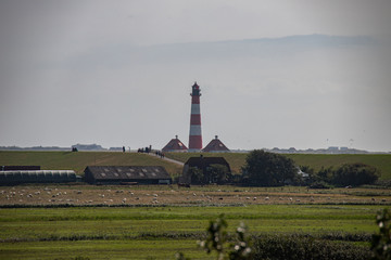 Fototapeta na wymiar Leuchtturm Westerheversand mit SPO im Hintergrund