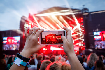 Hand with a smartphone records live music festival, live concert, live concert