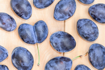 Fruit background. Fresh ripe plums on wooden table.