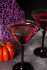 Two glasses with red cocktail for Halloween party on the dark background