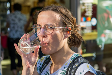 Female brunette tasting delicious bevarage at outdoor market place.