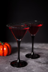 Two glasses with red cocktail for Halloween party on the dark background