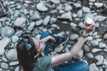 Young woman holding a glass with fresh beer outdoors