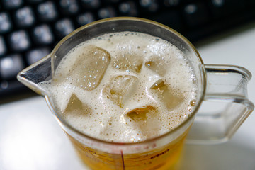 Bubbling beer in a glass with cool ice