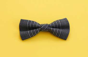 Bow tie made of costume fabric. Yellow solid isolation background. 