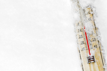 Thermometer on the snow, low temperature centigrade or Fahrenheit with copy space.