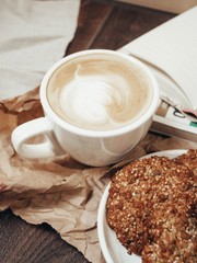 cup of coffee with milk and chocolate cookies