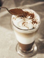 cocoa is poured with a small spoon on the froth