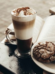 cup of coffee on a black table with book