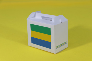 Gabonese flag on white box with barcode and the color of nation flag on yellow background. The...