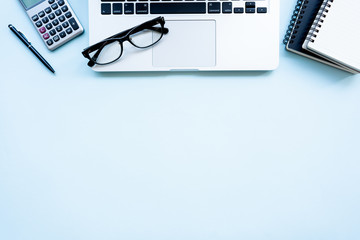 Flat lay,Top view office table desk. Workspace with calculator, pen , laptop , note on the pastel blue background.Copy Space for text,Empty Blank to word.Business Finance,Education Technology Concept.