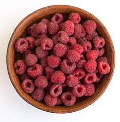 Fresh raspberries background closeup photo. Red raspberries in ceramic bowl.