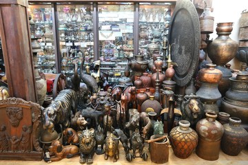 Dubai antique products at a market. Brass jars and wooden sculptures.
