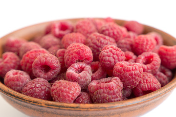 Fresh raspberries background closeup photo. Red raspberries in ceramic bowl.