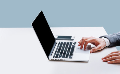 Businessman sitting behind the desk, working with laptop at office