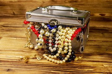 Jewelry box full of jewelry and accessories on wooden background