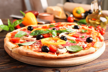 Delicious pizza and ingredients on wooden background, close up