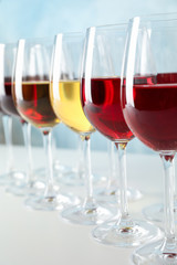 Glasses with different wine on wooden background, space for text