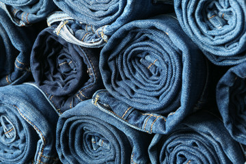 Stack rolled jeans texture on whole background, close up