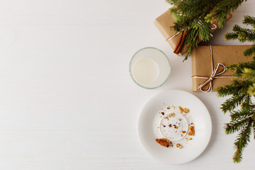 Empty glass of milk and crumb biscuits and a gift under the Christmas tree. The concept of the arrival of Santa Claus.