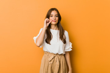 Young caucasian woman with fingers on lips keeping a secret. © Asier