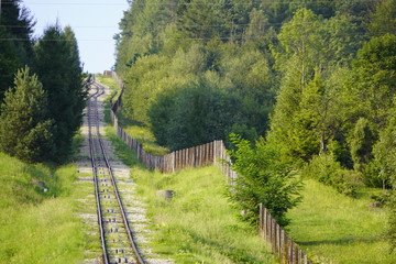 railway for the trailer in the mountains at the fence, the mountains in the summer in the grass and...