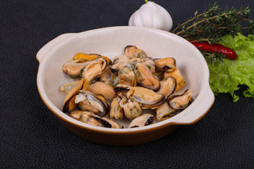 Pickled mussels in the bowl served pepper, garlic and salad