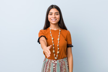 Young arab woman stretching hand at camera in greeting gesture. © Asier