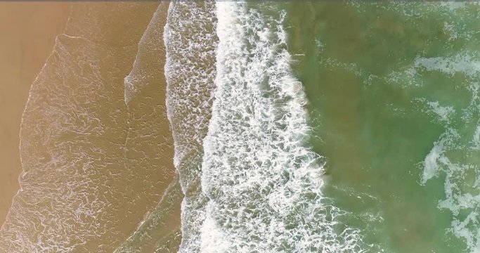 Vista cenital dron de playa dorada y olas verdas