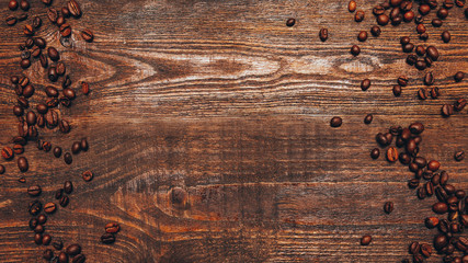Rustic background. Coffee shop. Roasted beans on brown wooden surface.