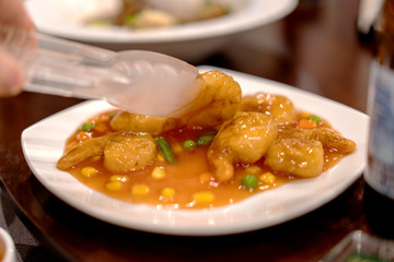 Shrimps in a sweet sour sauce being picked up