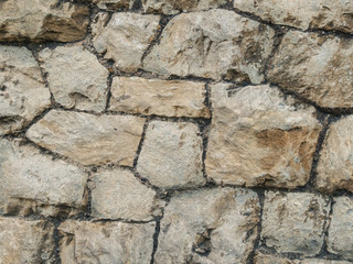 Old brown and gray cobblestone wall texture.
