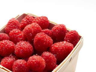 Small baskets of farmers market ready pints, 550ml, of freshly picked raspberry on a garden work...