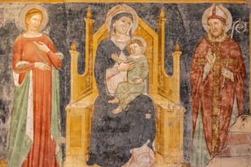 Ruins of medieval religious fresco showing Mary and Jesus watched by other two catholic saints © Giorgio G