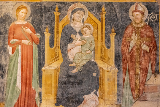 Ruins of medieval religious fresco showing Mary and Jesus watched by other two catholic saints
