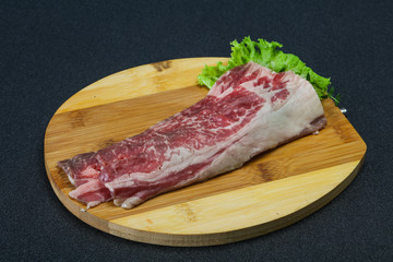 Raw beef bacon over wooden board