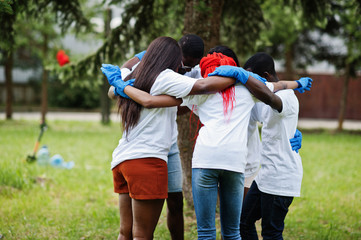 Group of happy african volunteers hugs in park. Africa volunteering, charity, people and ecology...