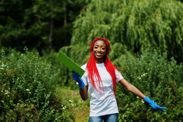 African red haired volunteer woman with clipboard in park. Africa volunteering, charity, people and ecology concept.