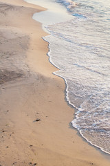 The vertical image of the edge of the sandy shore and the sea. Sea vacation concept. Place for text. Copy space.