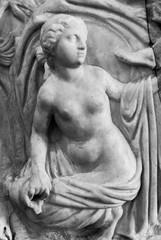 Sculpture of nude young woman engraved on marble wall - black and white photo