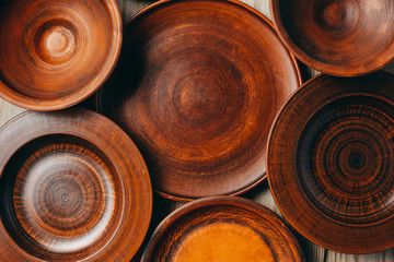 Clay dishes background. Group of brown clay plates top view flat lay. Copy space, place for text.