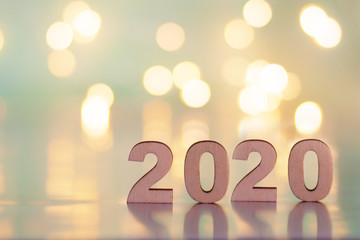 The inscription 2020, New Year and Christmas, from behind blurred dots of light on a blue background. Christmas and holiday.