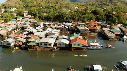 Old wooden house standing on the sea in the fishing village. Busuanga, Coron, Philippines. houses community standing in water in fishing village. Coron city with slums and poor district.