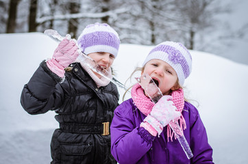 Fototapeta premium little girl licking frozen icicles