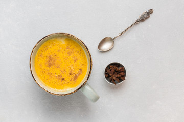 Turmeric latte with milk and cinnamon. Elixir of health and vivacity. Traditional healthy Indian detox drink. White background, top view, copy space