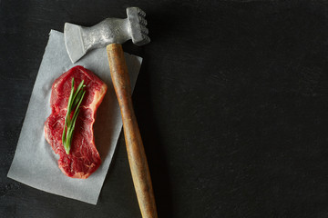 Meat steak with chop hammer and rosemary top view flat lay copy-space. Place for text.