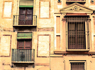 Fototapeta na wymiar Louvered windows on the facade of an old house in the spanish city of Granada